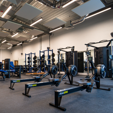 Gym interior with rowing machines and squat racks