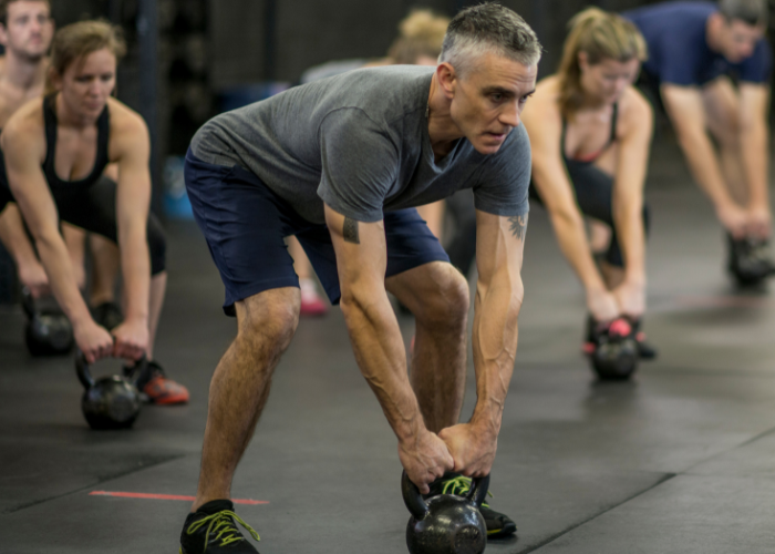 FITNESS CLASSES Chigwell Man working out with kettlebell in a fitness class